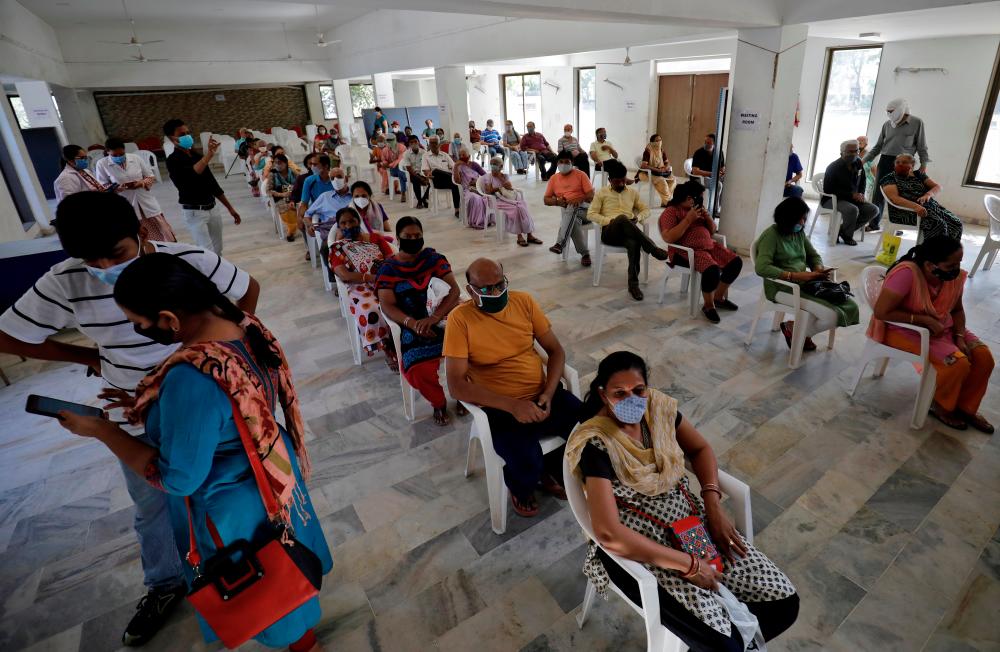 FILE PHOTO: People sit in a waiting area to receive a dose of COVISHIELD, a coronavirus disease (Covid-19) vaccine manufactured by Serum Institute of India, at a vaccination centre in Ahmedabad, India, April 2, 2021. - Reuters