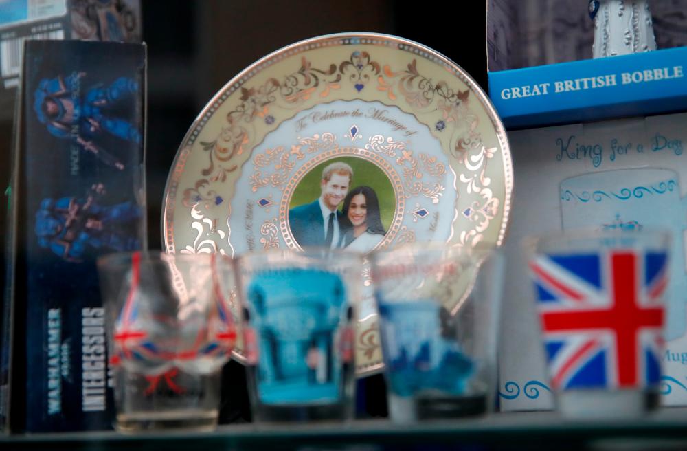 Souvenirs with pictures of Britain's Prince Harry and Meghan, Duchess of Sussex are displayed in a souvenir shop window, after Britain's Prince Philip, husband of Queen Elizabeth, died at the age of 99, in Windsor, near London, Britain, April 10, 2021. –Reuters
