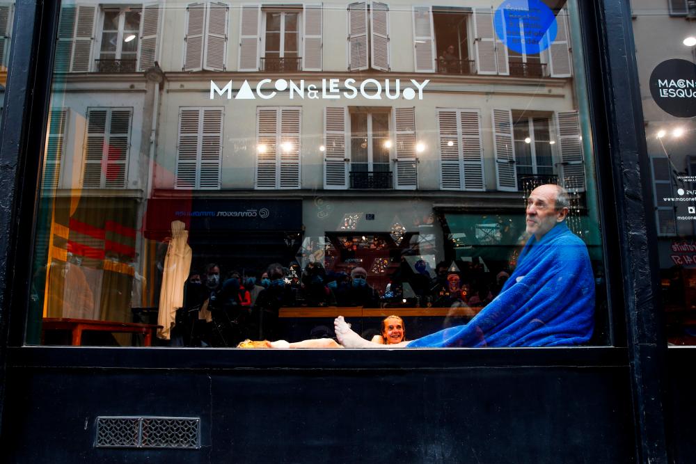 French artists Isabelle Cagnat and Etienne Coquereau perform the play Les amnesiques n'ont rien vecu d'inoubliable (Amnesiacs have not experienced anything unforgettable) behind a store window as theatres and non-essential stores remain closed across the country amid the coronavirus disease (COVID-19) outbreak in Paris, France, April 11, 2021. –Reuters
