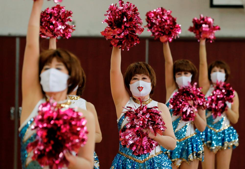 Fumie Takino, 89, founder of a senior cheer squad called Japan Pom Pom, and other Japan Pom Pom members, perform a dance routine while filming an online performance in Tokyo, Japan, April 12, 2021. -Reuters