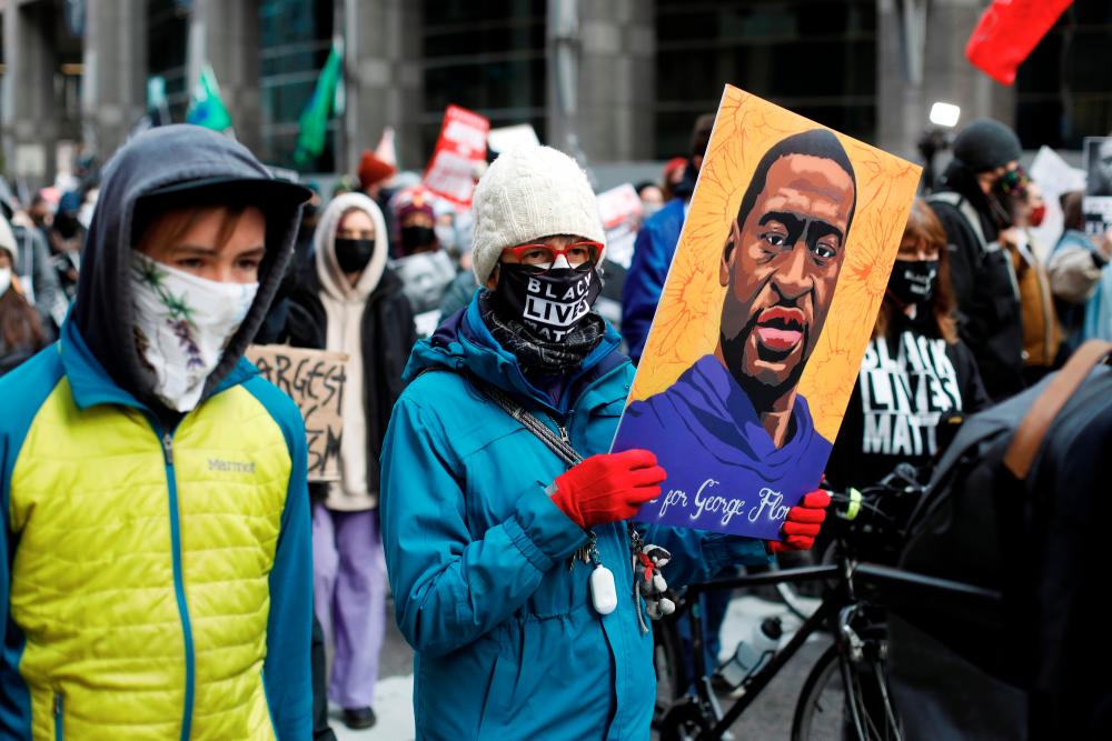 Demonstrators march through downtown Minneapolis demanding justice for George Floyd and Daunte Wright while jury deliberations begin for former Minneapolis Police officer Derek Chauvin’s murder trial at the Hennepin County Government Center in Minneapolis, Minnesota, U.S. April 19, 2021. - Reuters