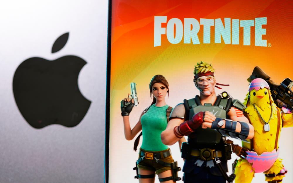 Fortnite game graphic is displayed on a smartphone in front of Apple logo in this illustration taken, May 2, 2021. –Reuters