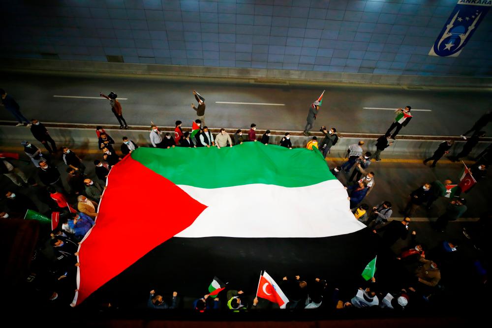 Demonstrators march with a huge Palestinian flag during a protest against Israel in Ankara, Turkey late May 10, 2021. –Reuters