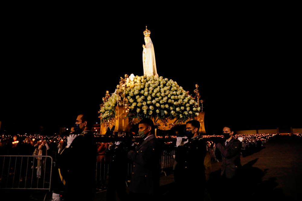 People carry the statue of Our Lady of Fatima during the 104th anniversary of the appearance of the Virgin Mary to three shepherd children at the Catholic shrine of Fatima, Portugal, May 12, 2021. -Reuters