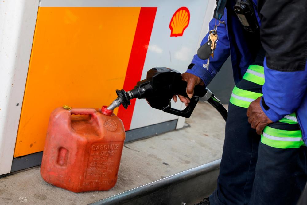 A person fills a fuel container at a Shell gas station, after a cyberattack crippled the biggest fuel pipeline in the country, run by Colonial Pipeline, in Washington, DC, US, May 15, 2021. - Reuters