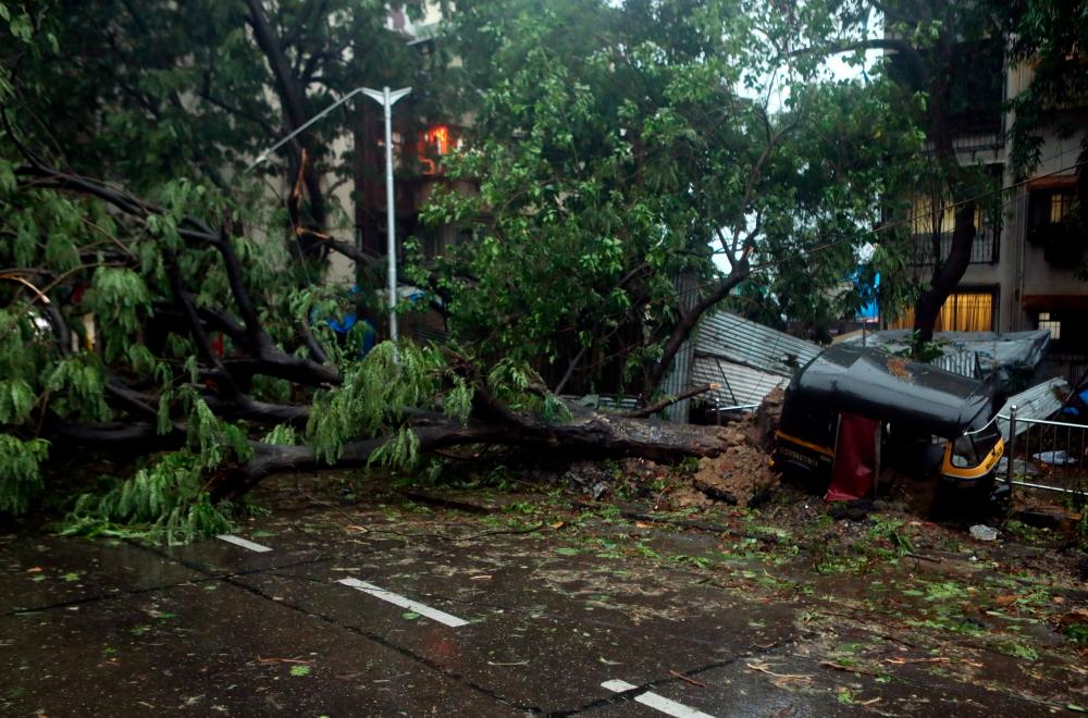 An uprooted tree is seen on a road after strong winds caused by Cyclone Tauktae in Mumbai, India May 17, 2021. – Reuters