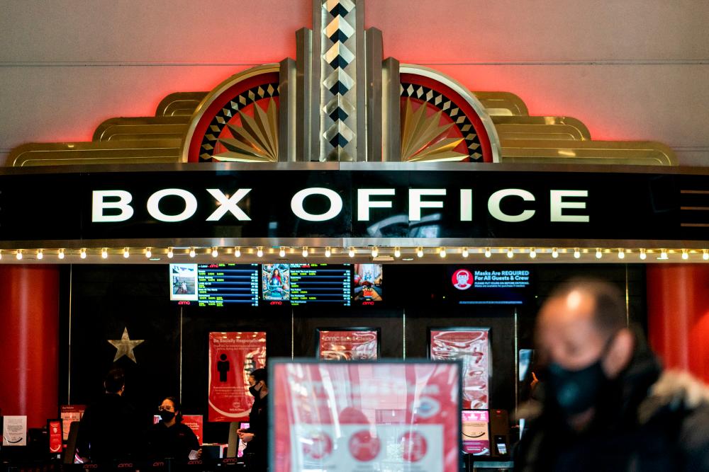 FILE PHOTO: A guest purchases a ticket in front of a box office at AMC movie theater in Lincoln Square, amid the coronavirus disease (Covid-19) pandemic, in the Manhattan borough of New York City, New York, U.S., March 6, 2021.- Reuters