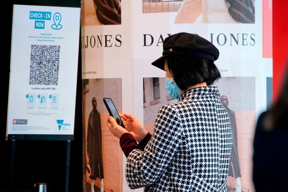 FILE PHOTO: A shopper wearing a protective face mask scans a QR code before entering a store on the first day of eased coronavirus disease (COVID-19) restrictions for the state of Victoria following an extended lockdown in Melbourne, Australia, June 11, 2021. – Reuters
