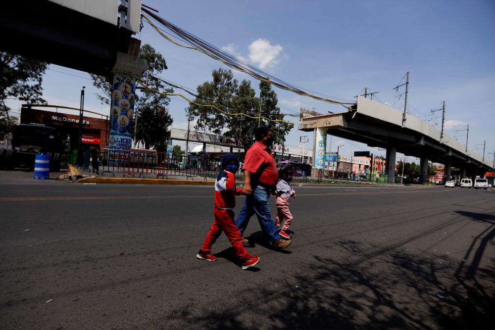 People walk near the site of a deadly metro overpass accident that collapsed last month and left 26 people dead, which was caused by a structural fault according to the preliminary findings of an independent investigation by Norwegian firm DNV, in Mexico City, Mexico June 16, 2021.- Reuters