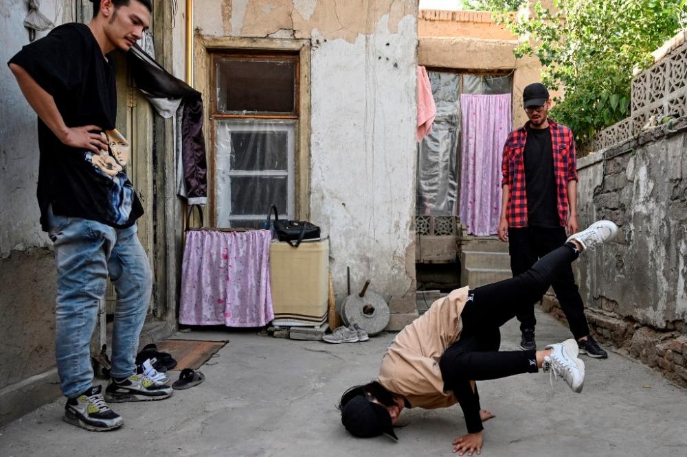 In this photo taken on June 12, 2021, Manizha Talash (centre), the only female member of a group of breakdancers comprised of mostly Hazara boys, practices a move as two members of her troupe look on in Kabul. — AFP