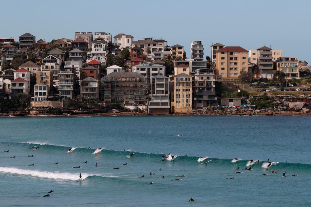 Surfers catch a wave at Bondi Beach during a lockdown to curb the spread of a coronavirus disease (Covid-19) outbreak in Sydney, Australia, July 27, 2021. - Reuters