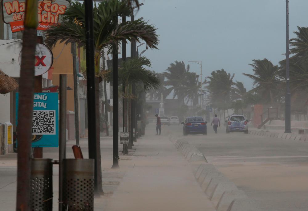 People walk near the beach after Hurricane Grace made landfall on the Yucatan Peninsula, in Progreso, Mexico, August 19, 2021. -Reuters