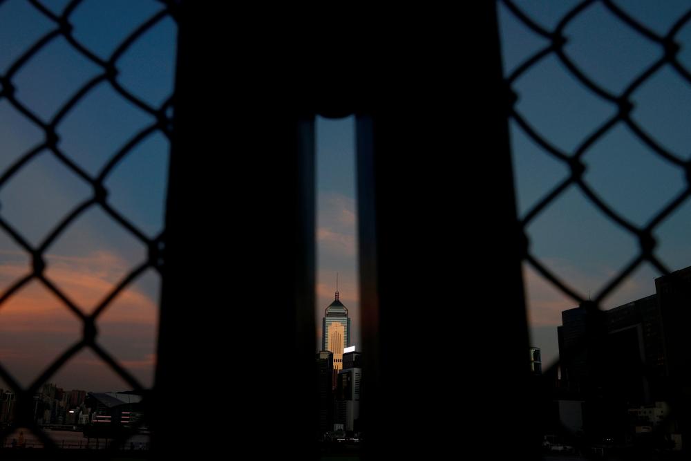 The Central Plaza is seen through a fence during sunset in Hong Kong, China August 17, 2021. -Reuters
