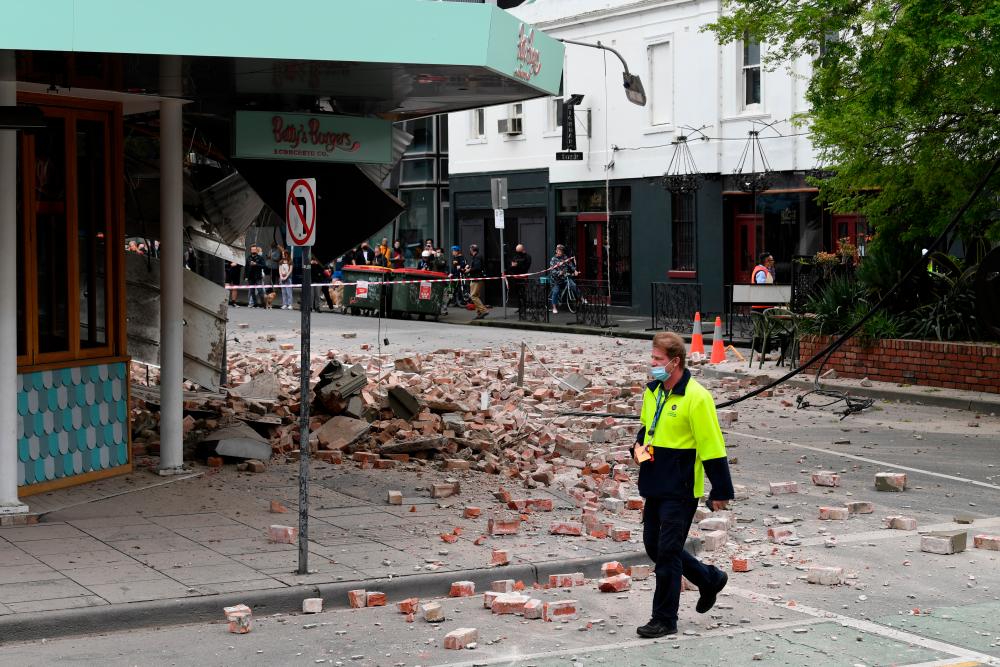 A person walks past damage to the exterior of a restaurant following an earthquake in the Windsor suburb of Melbourne, Australia, September 22, 2021. AAP Image/James Ross via REUTERS ATTENTION EDITORS - THIS IMAGE WAS PROVIDED BY A THIRD PARTY. NO RESALES. NO ARCHIVES. AUSTRALIA OUT. NEW ZEALAND OUT