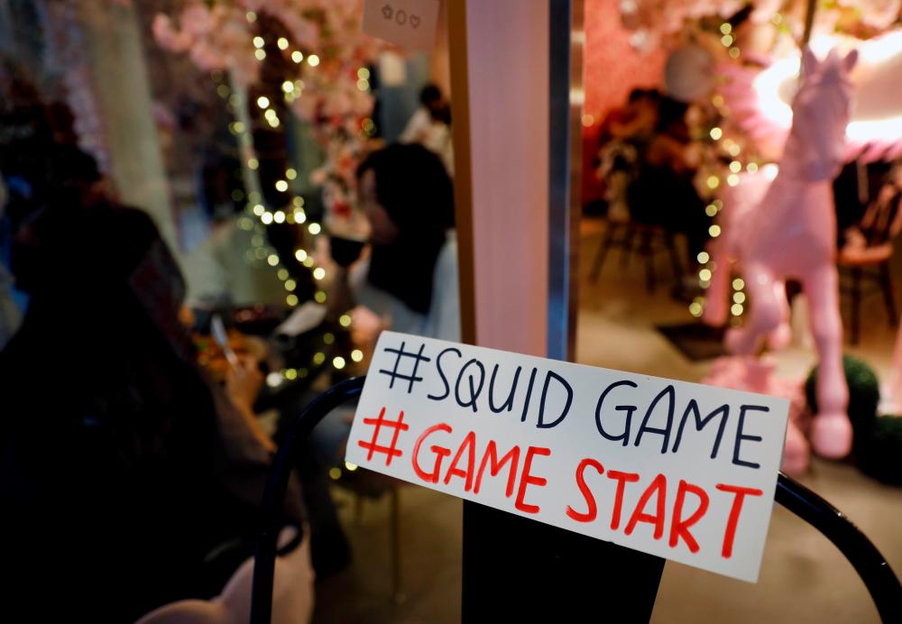 A sign referring to the “honeycomb challenge” featured in Netflix’s new hit series “Squid Game” is seen at Brown Butter Cafe in Singapore October 1, 2021. REUTERSpix