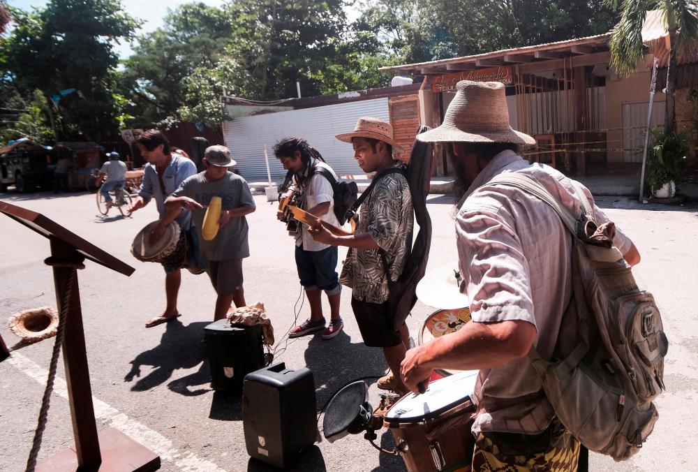 Musicians play songs to collect coins from tourists near a restaurant where, according to local media, two foreigners were killed and three injured during a shooting occurred between suspected gang members, in Tulum, Mexico, October 22, 2021. REUTERSpix