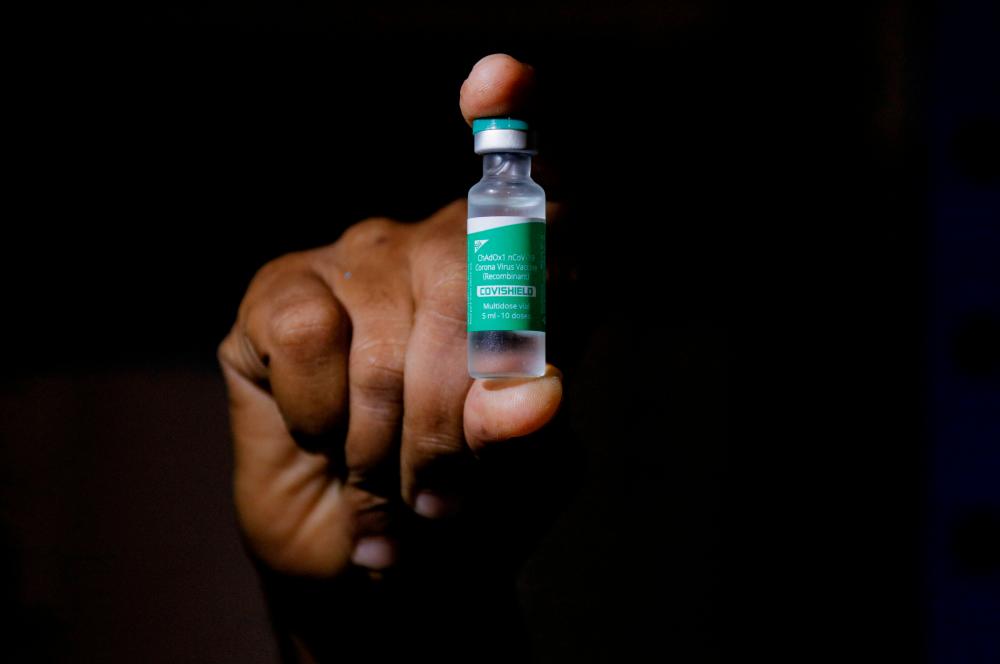 FILE PHOTO: A man displays a vial AstraZeneca's COVISHIELD vaccine as the country receives its first batch of coronavirus disease (COVID-19) vaccines under COVAX scheme, in Accra, Ghana February 24, 2021. REUTERSpix