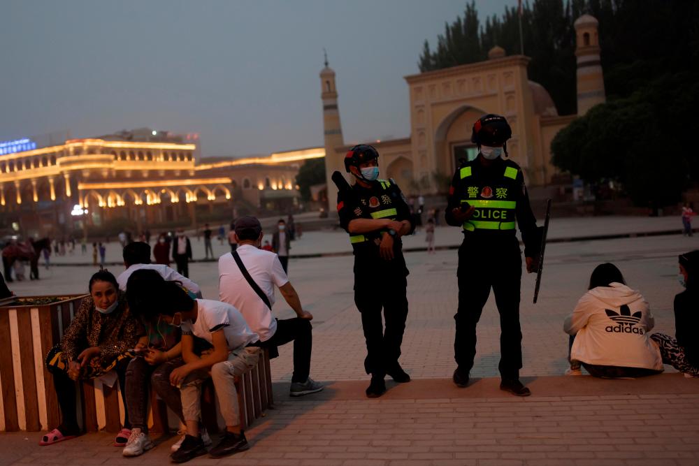 FILE PHOTO: Police officers patrol the square in front of Id Kah Mosque in Kashgar, Xinjiang Uyghur Autonomous Region, China, May 3, 2021. Picture taken May 3, 2021. REUTERSpix