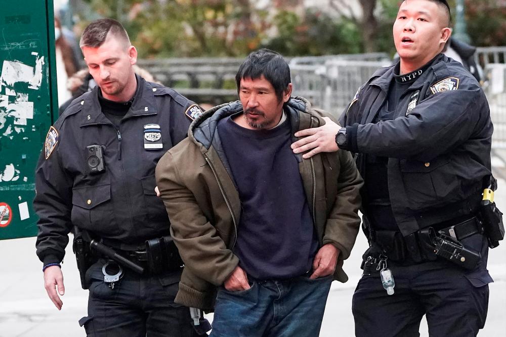 Craig Tamanaha, who was later charged with setting fire to a Christmas tree outside the Fox News headquarters, is detained by police after exposing himself outside the court at the trial of Ghislaine Maxwell in the Manhattan borough of New York City, New York, U.S., November 29, 2021. Picture taken November, 29, 2021. REUTERSpix