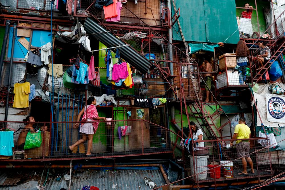 FILE PHOTO: Residents of a small apartment building do house chores outside their units, amid the lockdown to contain the coronavirus disease (COVID-19), in a slum area in Tondo, Manila, Philippines, May 4, 2020. Picture taken May 4, 2020. REUTERSpix