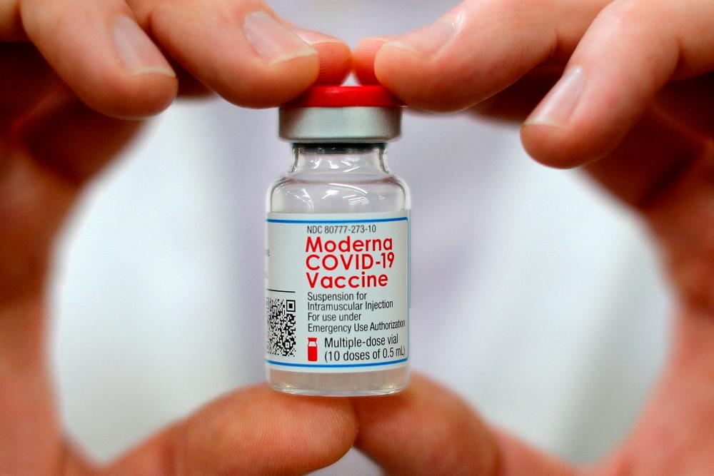 FILE PHOTO: A pharmacist holds a vial of the Moderna coronavirus disease (COVID-19) vaccine in West Haven, Connecticut, U.S., February 17, 2021. REUTERSPIX