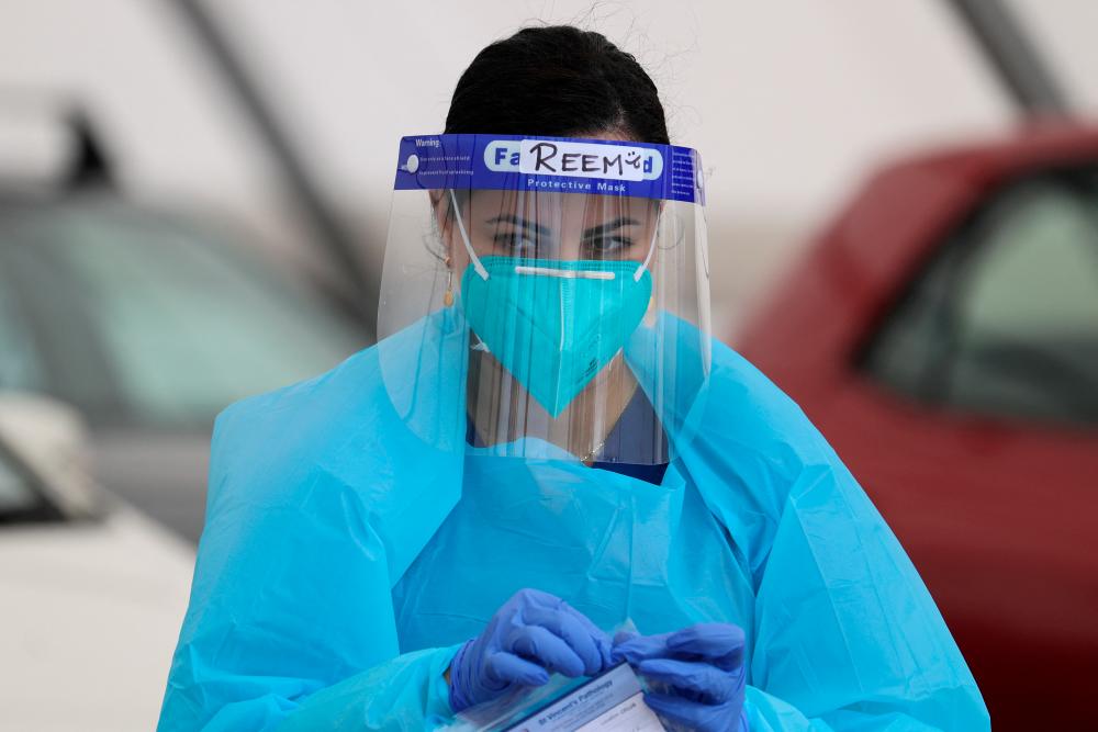 A medical worker is seen while administering tests at the Bondi Beach drive-through coronavirus disease (COVID-19) testing centre in the wake of an outbreak in Sydney, Australia, December 22, 2020. REUTERSPIX