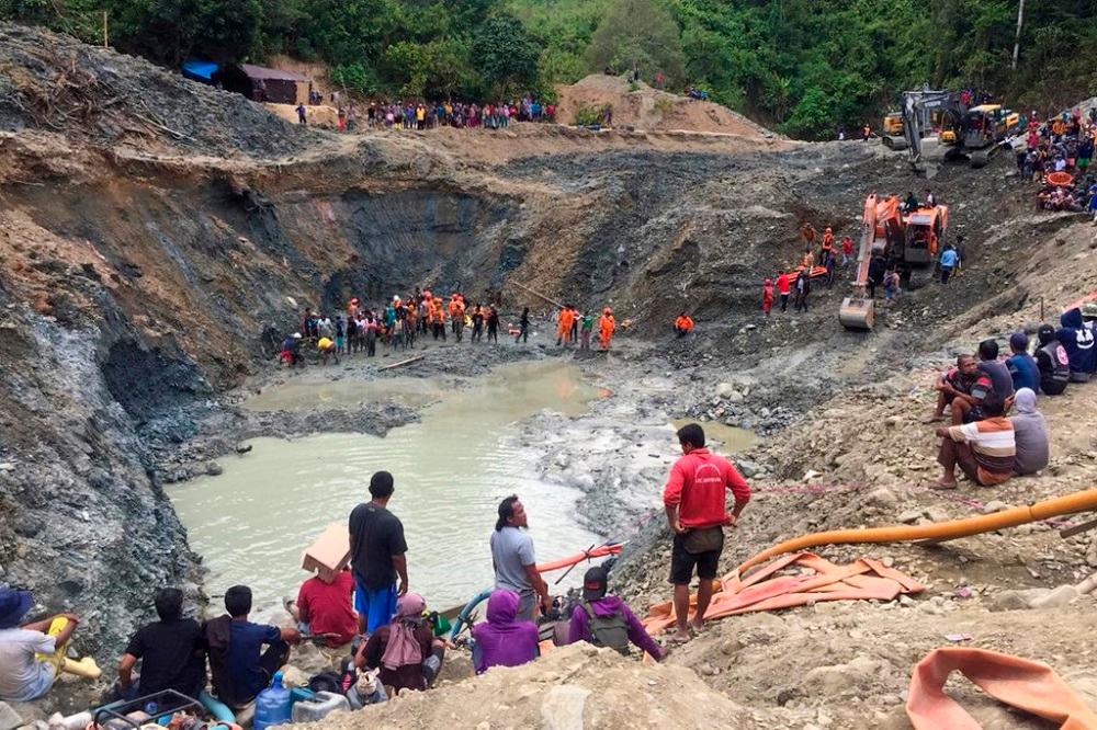 Rescue teams conduct a search for miners buried by a landslide at an illegal gold mining operation in the village of Buranga in Parigi Moutong Regency, Central Sulawesi February 25, 2021. — AFP