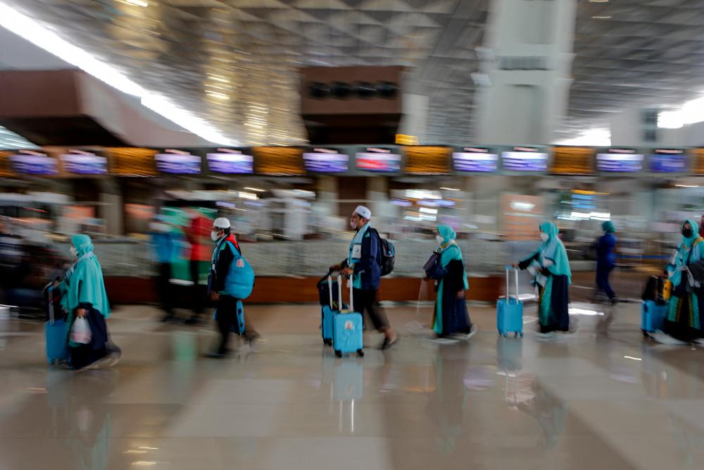 Pilgrims wearing protective face masks walk at Soekarno-Hatta International Airport, as Indonesian Muslims depart for Umrah pilgrimage trip for the first time since the beginning of the coronavirus disease (COVID-19) pandemic, in Tangerang, near Jakarta, Indonesia, January 8, 2022. REUTERSPIX