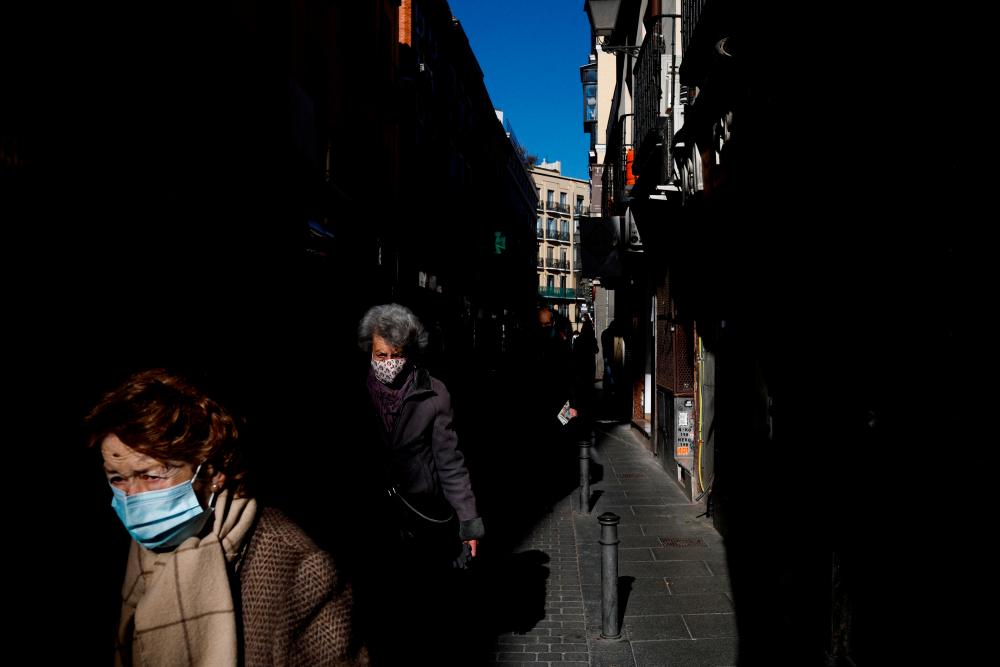 FILE PHOTO: Elderly women wearing face masks walk along a street amid the coronavirus disease (COVID-19) pandemic in Madrid, Spain, January 12, 2022. REUTERSPIX