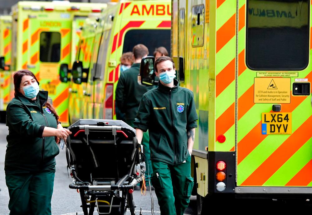 FILE PHOTO: Health workers move equipment between ambulances outside of the Royal London Hospital, amid the coronavirus disease (COVID-19) pandemic in London, Britain, January 7, 2022. REUTERSpix