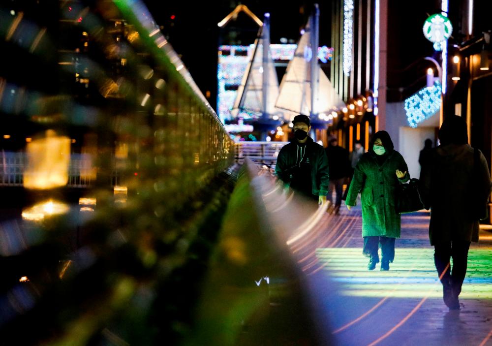 Visitors wearing protective face masks walk on a pedestrian deck, amid the coronavirus disease (COVID-19) pandemic, in Tokyo, Japan January 22, REUTERSPIX