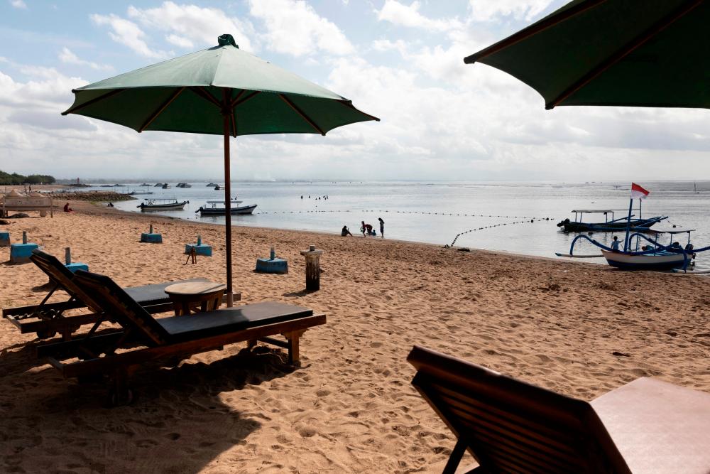 FILE PHOTO: Tourists play at a beach while Indonesia prepares to impose emergency measures tightening restrictions in Java and Bali as coronavirus disease (COVID-19) cases surge, in Sanur, Bali, Indonesia, July 2, 2021. REUTERSPIX