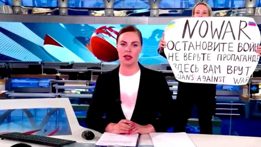 A person interrupts a live news bulletin on Russia's state TV Channel One holding up a sign that reads NO WAR. Stop the war. Don't believe propaganda. They are lying to you here. at an unknown location in Russia March 14, 2022, in this still image obtained from a video uploaded on March 14. AFPPIX