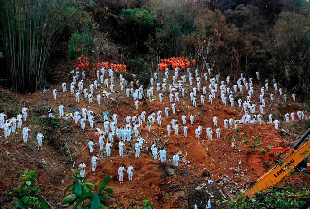 Filepix: Rescue workers stand in a silent tribute at the site to mourn the victims of a China Eastern Airlines Boeing 737-800 plane, flight MU5735, that crashed in Wuzhou, Guangxi Zhuang Autonomous Region, China, March 27, 2022/REUTERSPIX
