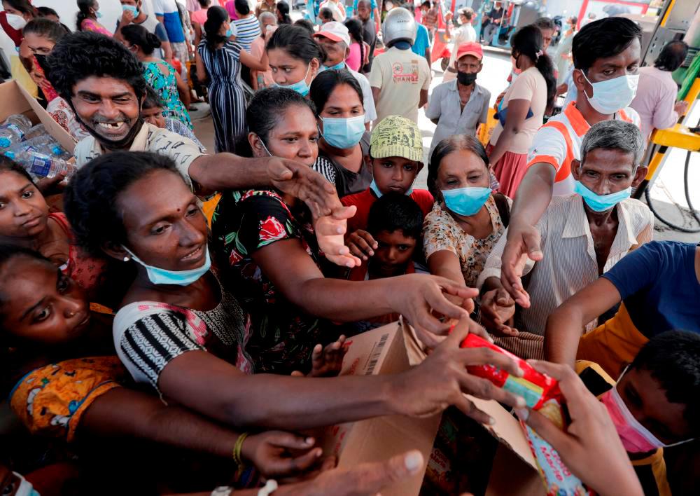 Filepix: People are given packets of biscuits from a free distributor, while waiting in line to buy kerosene near a Ceylon Petroleum Corporation fuel station, amid the country’s economic crisis in Colombo, Sri Lanka/REUTERSPix
