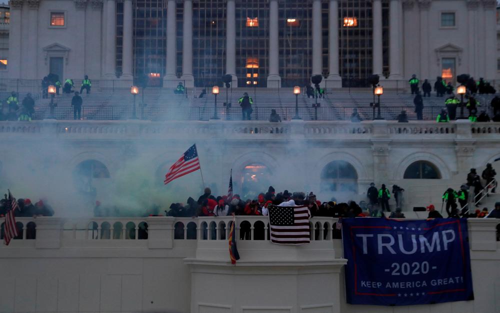 FILE PHOTO: Supporters of U.S. President Donald Trump react to tear gas during a clash with police officers in front of the U.S. Capitol Building in Washington, U.S., January 6, 2021. REUTERSPIX