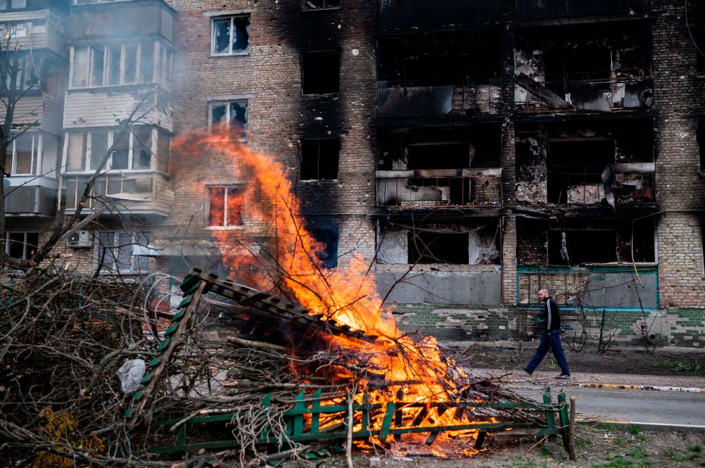 A person walks in front of a destroyed building, as Russia’s invasion of Ukraine continues, in Irpin, near Kyiv, Ukraine, April 19, 2022. REUTERSPIX
