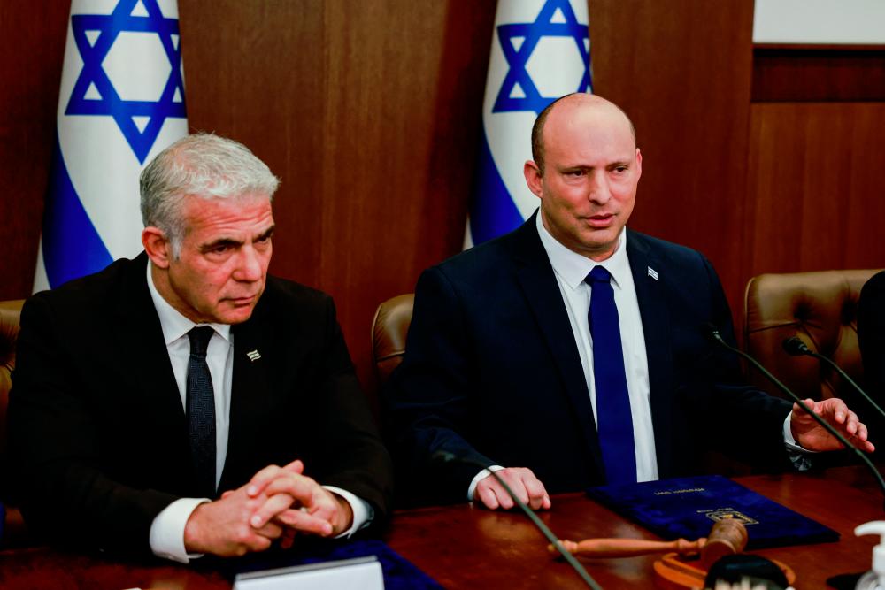 Israeli Prime Minister Naftali Bennett sits next to Foreign Minister Yair Lapid during a weekly cabinet meeting in Jerusalem. - REUTERSpix