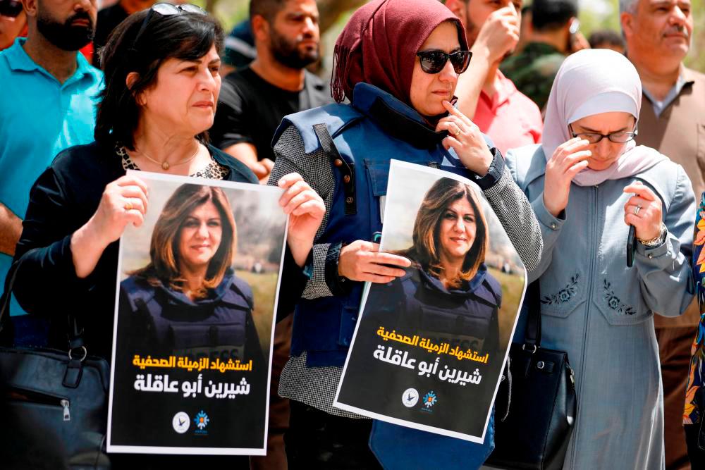 Palestinians hold pictures of Al Jazeera reporter Shireen Abu Akleh, who was killed by Israeli army gunfire during an Israeli raid, according to the Qatar-based news channel, in Nablus in the Israeli-occupied West Bank/REUTERSPix