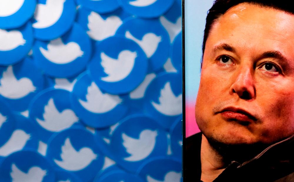 FILE PHOTO: An image of Elon Musk is seen on a smartphone placed on printed Twitter logos in this picture illustration taken April 28, 2022. REUTERSPIX