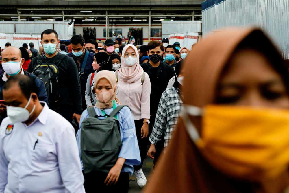 FILE PHOTO: People wearing protective masks walk through a platform of a train station during the afternoon rush hours as the Omicron variant continues to spread, amid the coronavirus disease (Covid-19) pandemic, in Jakarta, Indonesia, January 3, 2022. REUTERSPIX