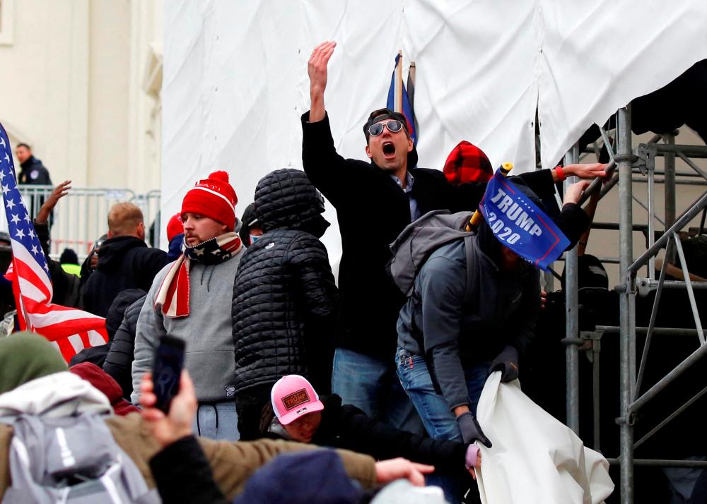 A man, identified as Ryan Kelley in a sworn statement by an FBI agent, gestures as supporters of U.S. President Donald Trump make their way past barriers at the U.S. Capitol during a protest against the certification of the 2020 U.S. presidential election results by the U.S. Congress, in Washington, U.S., January 6, 2021. REUTERSPIX