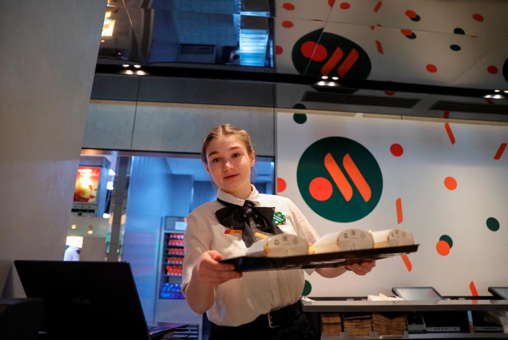 An employee takes part in preparations before the opening of the new restaurant Vkusno &amp; tochka following McDonald's Corp company's exit from the Russian market in Russia. - REUTERSPIX