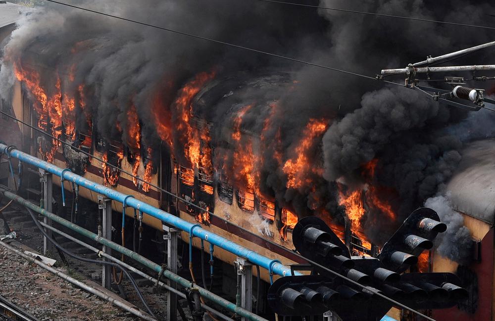 Smoke billows out from a passenger train coach after it was set on fire by protestors during a protest against “Agnipath scheme” for recruiting personnel for armed forces, in Secunderabad in the southern state of Telangana, India, June 17, 2022. REUTERSpix