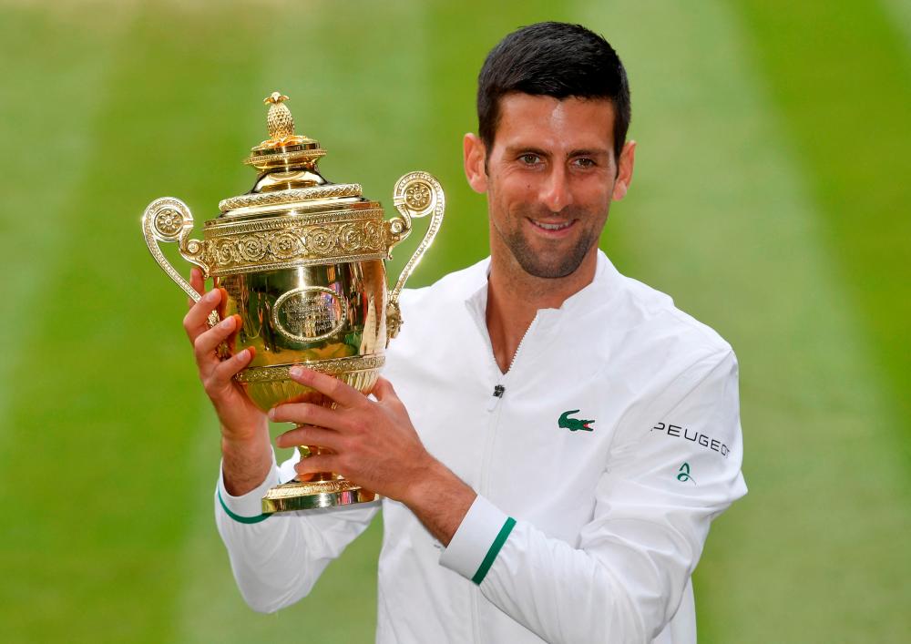 FILE PHOTO: Tennis - Wimbledon - All England Lawn Tennis and Croquet Club, London, Britain - July 11, 2021 Serbia’s Novak Djokovic celebrates with the trophy after winning his final match against Italy’s Matteo Berrettini REUTERSpix