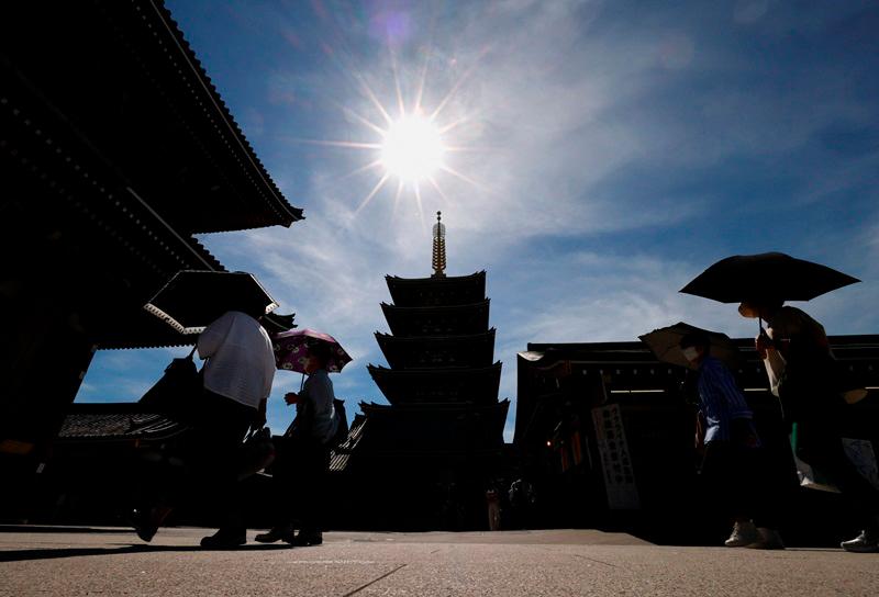 Visitors holding umbrellas stroll at Sensoji temple as Japanese government issues warning over possible power crunch due to heatwave in Tokyo, Japan June 29, 2022. - REUTERS/Issei Kato