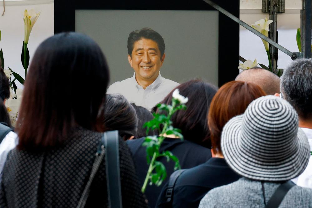 People gather to offer flowers at Zojoji Temple, where the funeral of late former Japanese Prime Minister Shinzo Abe, who was shot while campaigning for a parliamentary election, will be held, in Tokyo, Japan/REUTERSPix