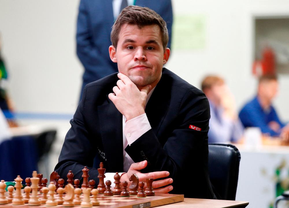 FILE PHOTO: Chess - 2018 World Rapid and Blitz Chess Championships - Rapid Open - Saint Petersburg, Russia - December 26, 2018. Magnus Carlsen of Norway plays against Adam Tukhaev of Ukraine. REUTERSPIX