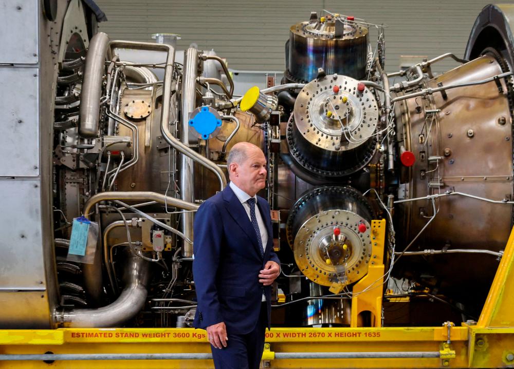 German Chancellor OIaf Scholz stands next to a gas turbine meant to be transported to the compressor station of the Nord Stream 1 gas pipeline in Russia during his visit to Siemens Energy’s site in Muelheim an der Ruhr, Germany, August 3, 2022. REUTERSPIX