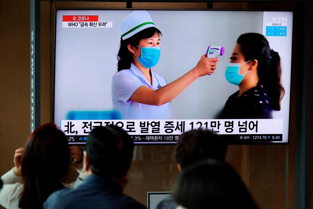 FILE PHOTO: People watch a TV broadcasting a news report on the coronavirus disease (COVID-19) outbreak in North Korea, at a railway station in Seoul, South Korea, May 17, 2022. REUTERSPIX